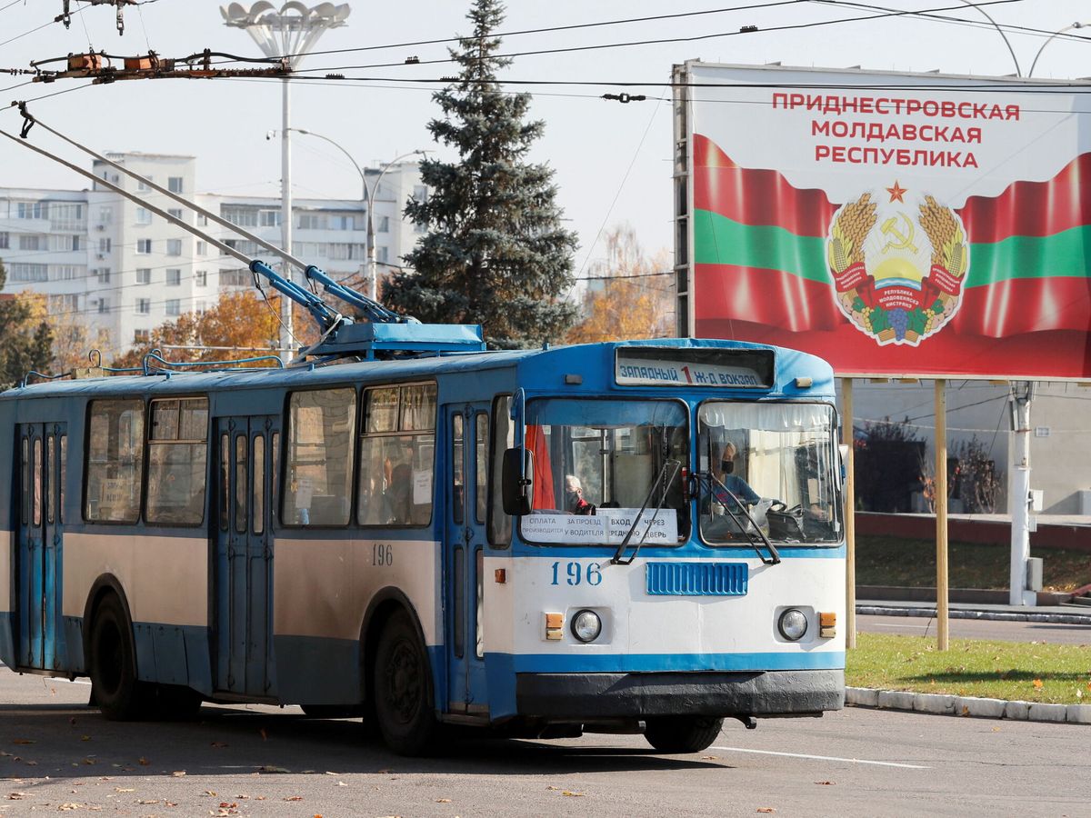 Foto: Un viejo trolebús pasa cerca de un cartel con el escudo de armas oficial en Tiráspol en Transnistria. (Reuters/Gleb Garanich)