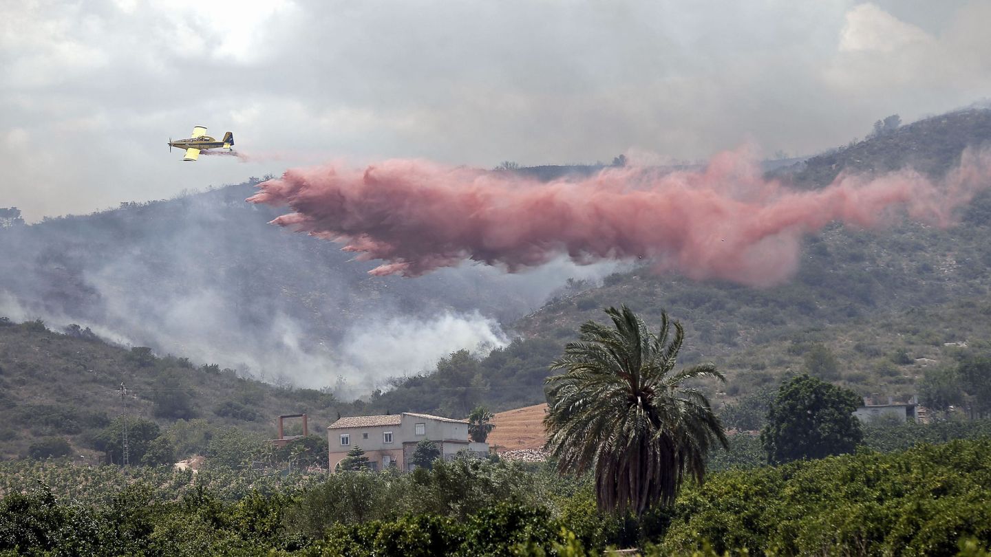 Una avioneta realiza una descarga sobre el frente del incendio cerca de Sumacàrcer (EFE)
