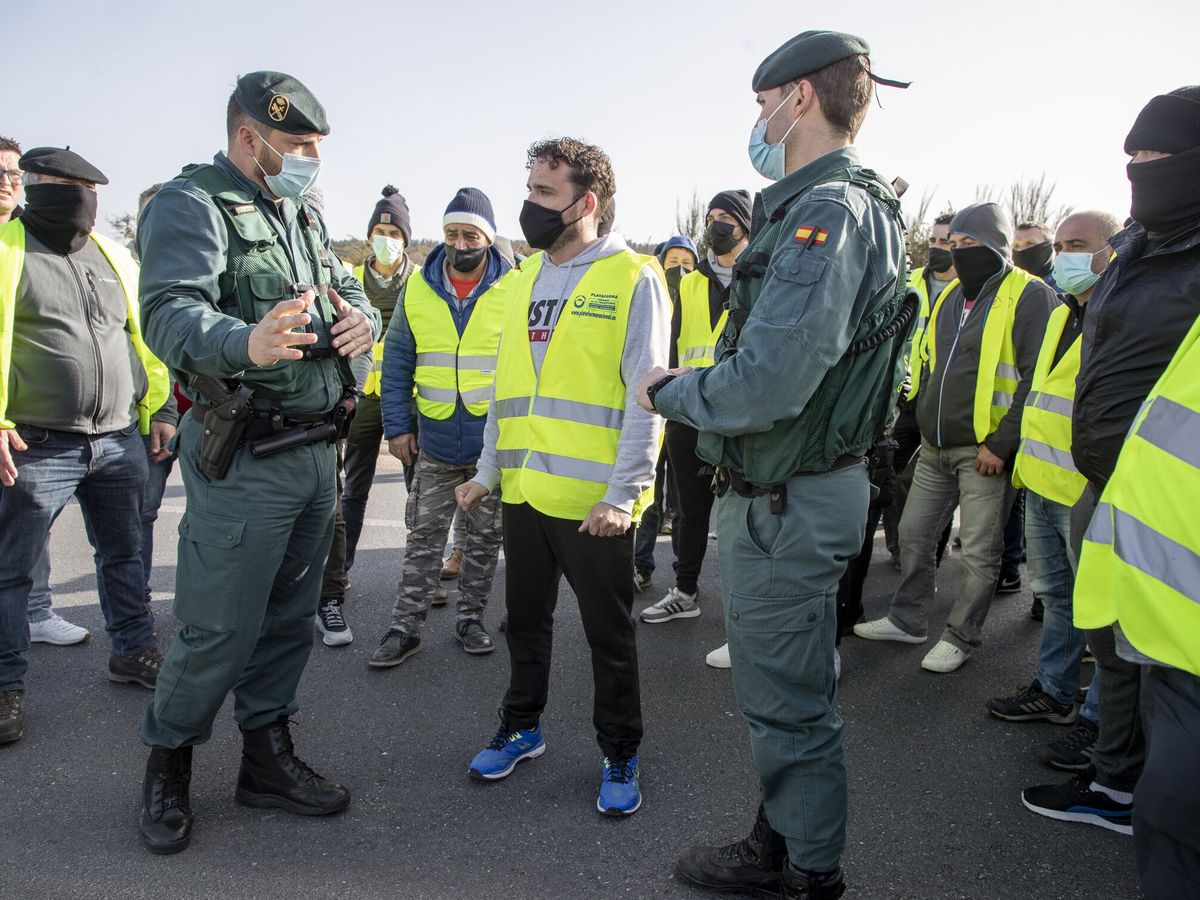 Foto: Agentes de la Guardia Civil dialogan con decenas de transportistas. (EFE / Eliseo Trigo)
