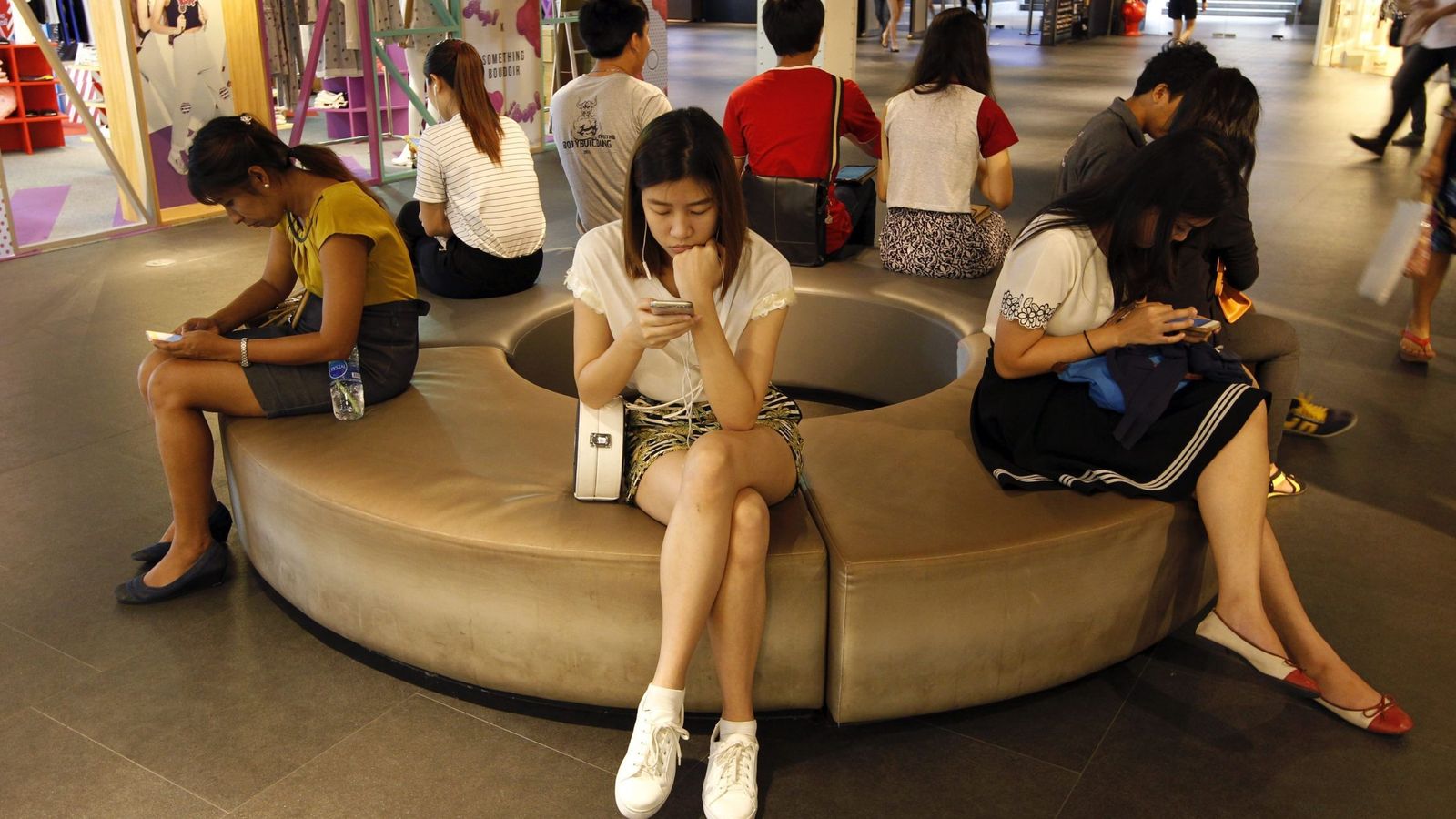 Foto: Tailandeses, leyendo en sus móviles. (EFE)