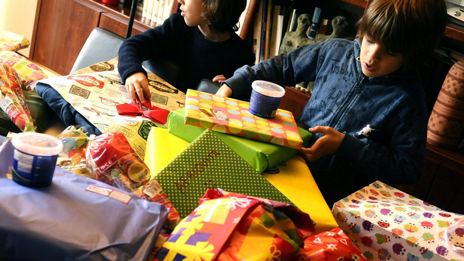 Foto: Unos niños abren los regalos que les han dejado los Reyes Magos, en una imagen de archivo (EFE)