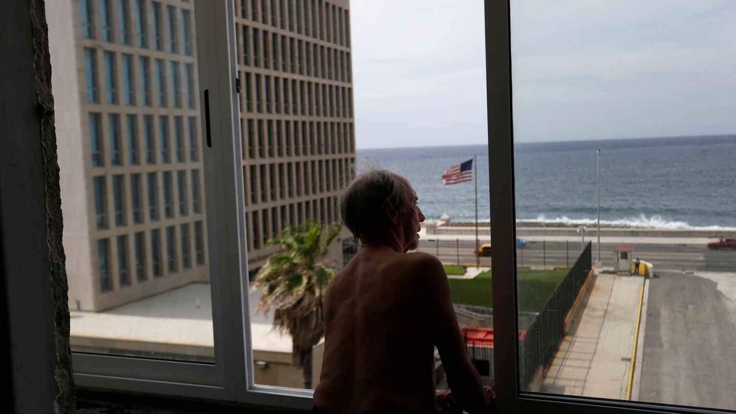 Un hombre mira por la ventana, con vistas a la Embajada de EEUU en La Habana, en junio de 2017. (Reuters)
