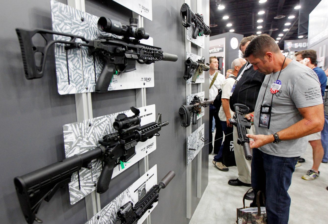 Un cliente inspecciona fusiles Sig Sauer en una reunión de la Asociación Nacional del Rifle (Foto: Reuters)