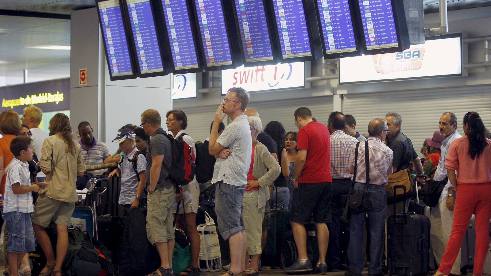 Foto: Un grupo de personas hacen cola en la zona de facturación del Aeropuerto de Barajas, en Madrid. (EFE) 