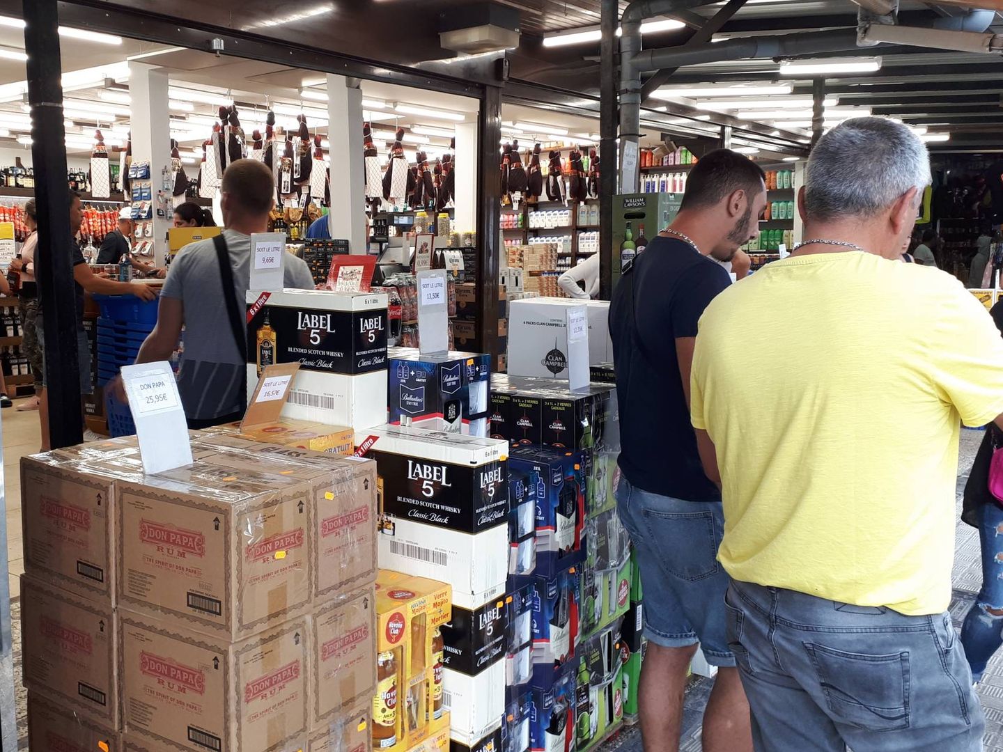 Ciudadanos franceses adquieren productos en uno de los establecimientos fronterizos de Behobia, donde destaca el alcohol y el jamón. (J. M. A.)