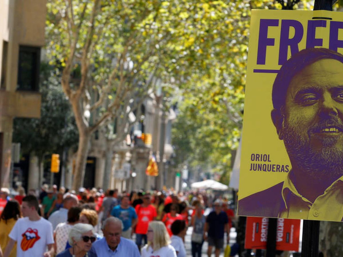 Foto: Manifestantes caminan junto a un cartel que pide la libertad de Junqueras. (Reuters)