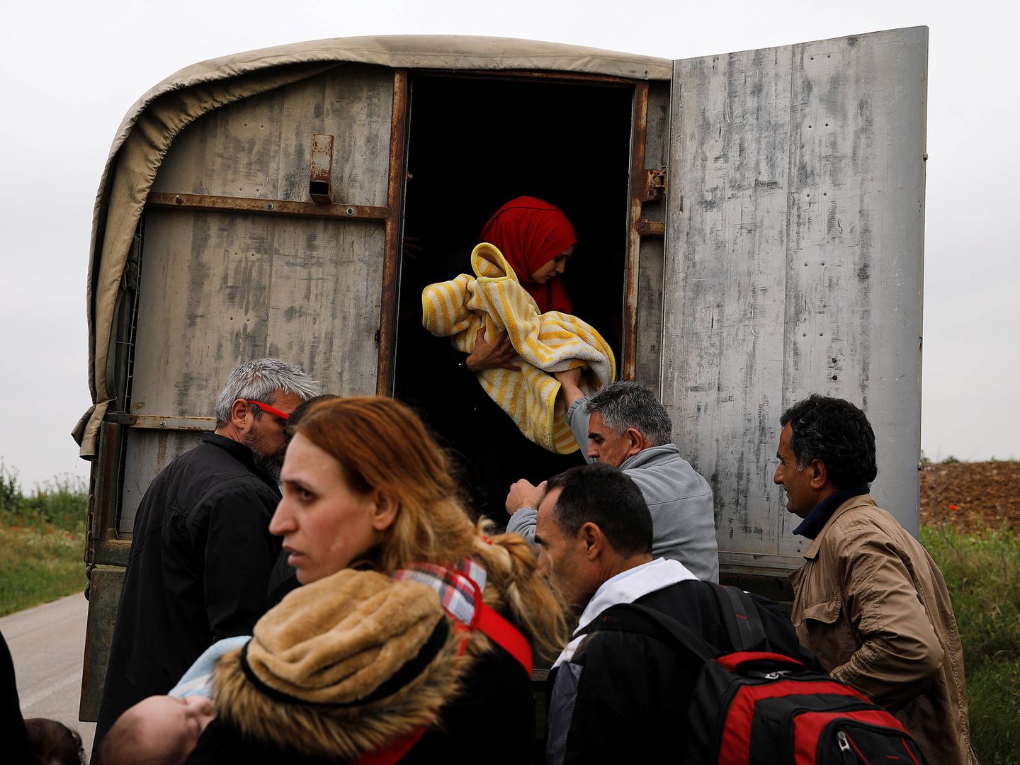 Refugiados sirios tras cruzar el río Evros, la frontera natural entre Grecia y Turquía, suben a un vehículo policial. (Reuters)   