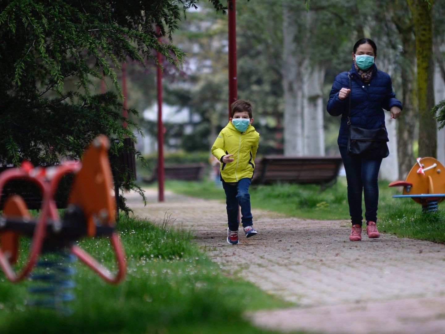 Un niño protegido con una mascarilla corre un parque de la ciudad de Valladolid. (EFE)