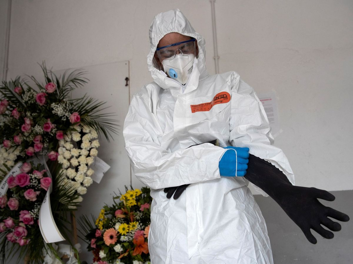 Foto: Un empleado funerario se protege con un Equipo de Protección Individual (EPI). (EFE)