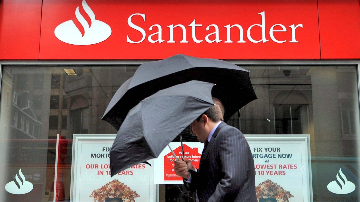 Imagen de archivo de dos hombres caminando junto a una oficina del banco Santander en Londres. (EFE)