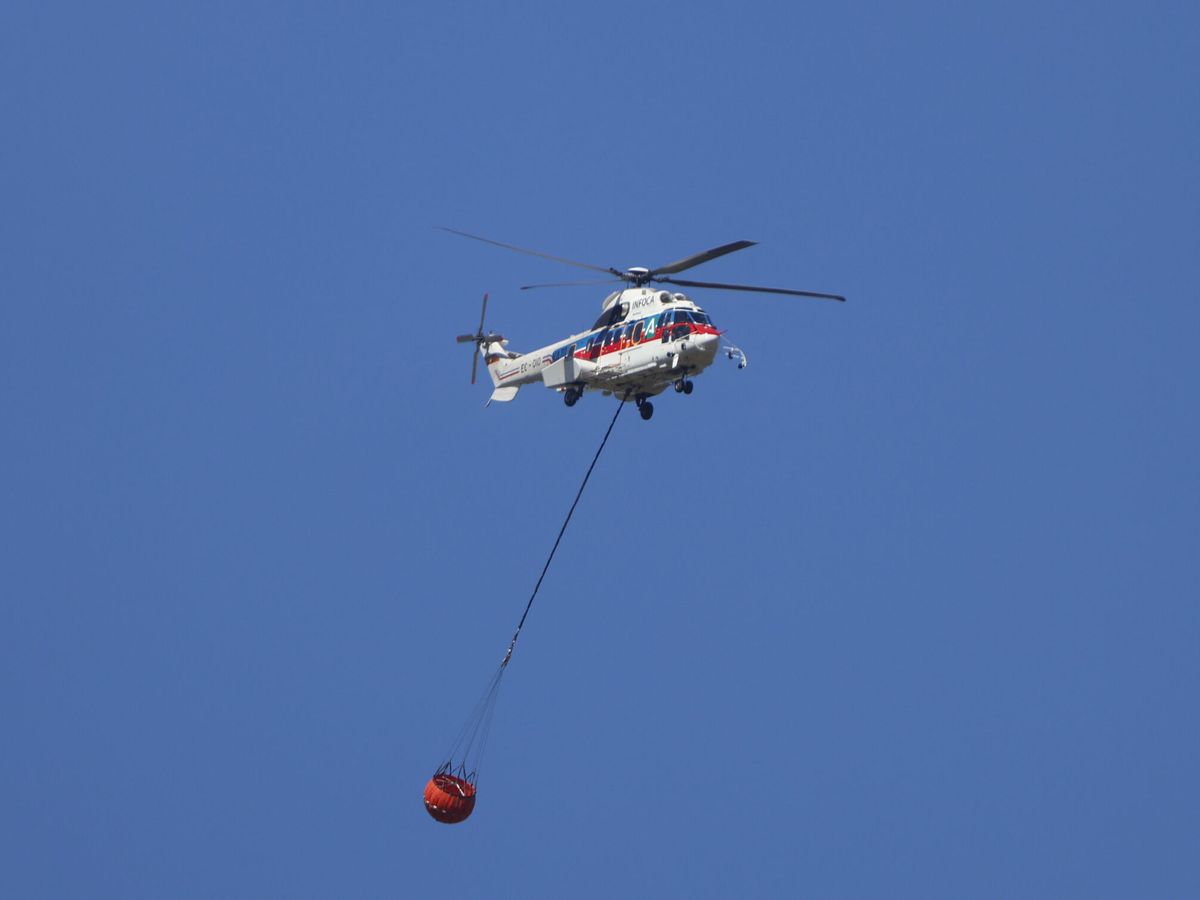 Foto: Helicóptero en el incendio forestal en el campo de tiro de la base militar de Cerro Murianohar. (EFE/Salas)