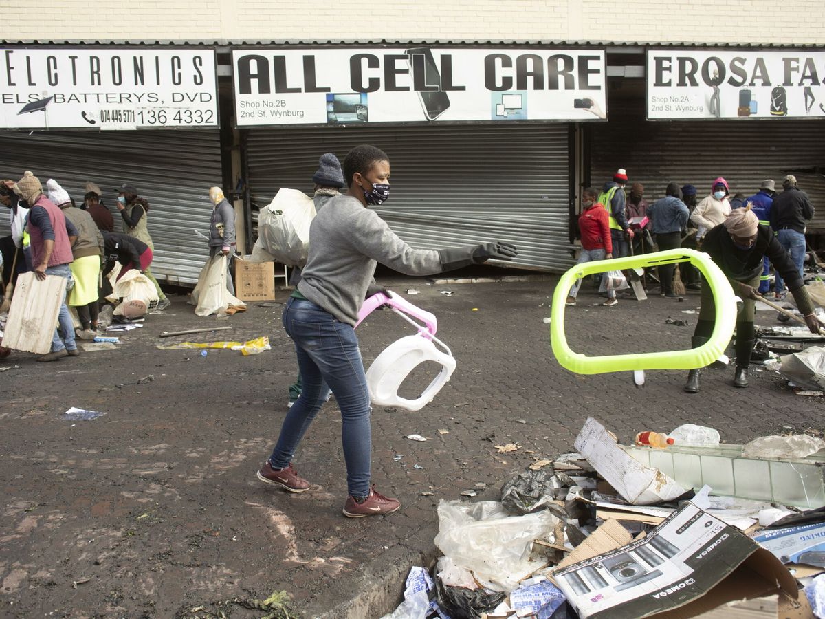 Foto: Residentes limpian las calles después de los saqueos en Johannesburgo. (EFE)