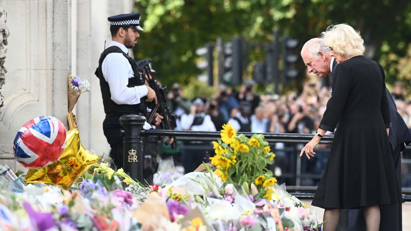 Carlos III y Camila observan los tributos florales a su llegada al palacio de Buckingham. (EFE/Neil Hall)