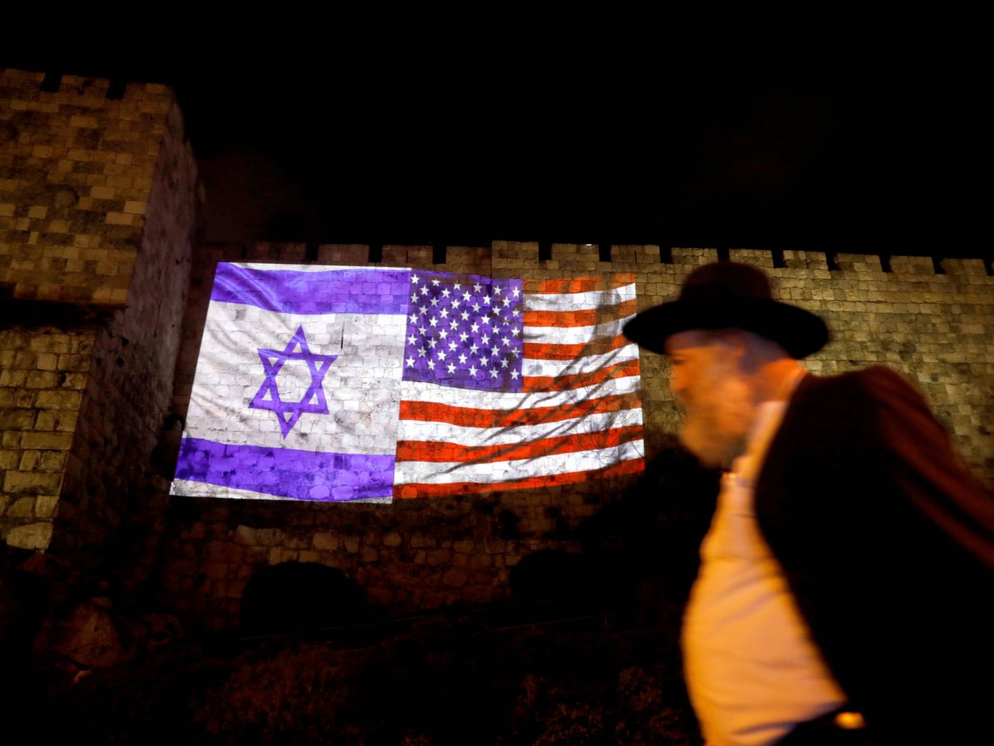 Un judío ultraortodoxo pasa ante las banderas estadounidense e israelí en la Ciudad Vieja de Jerusalén. (Reuters)
