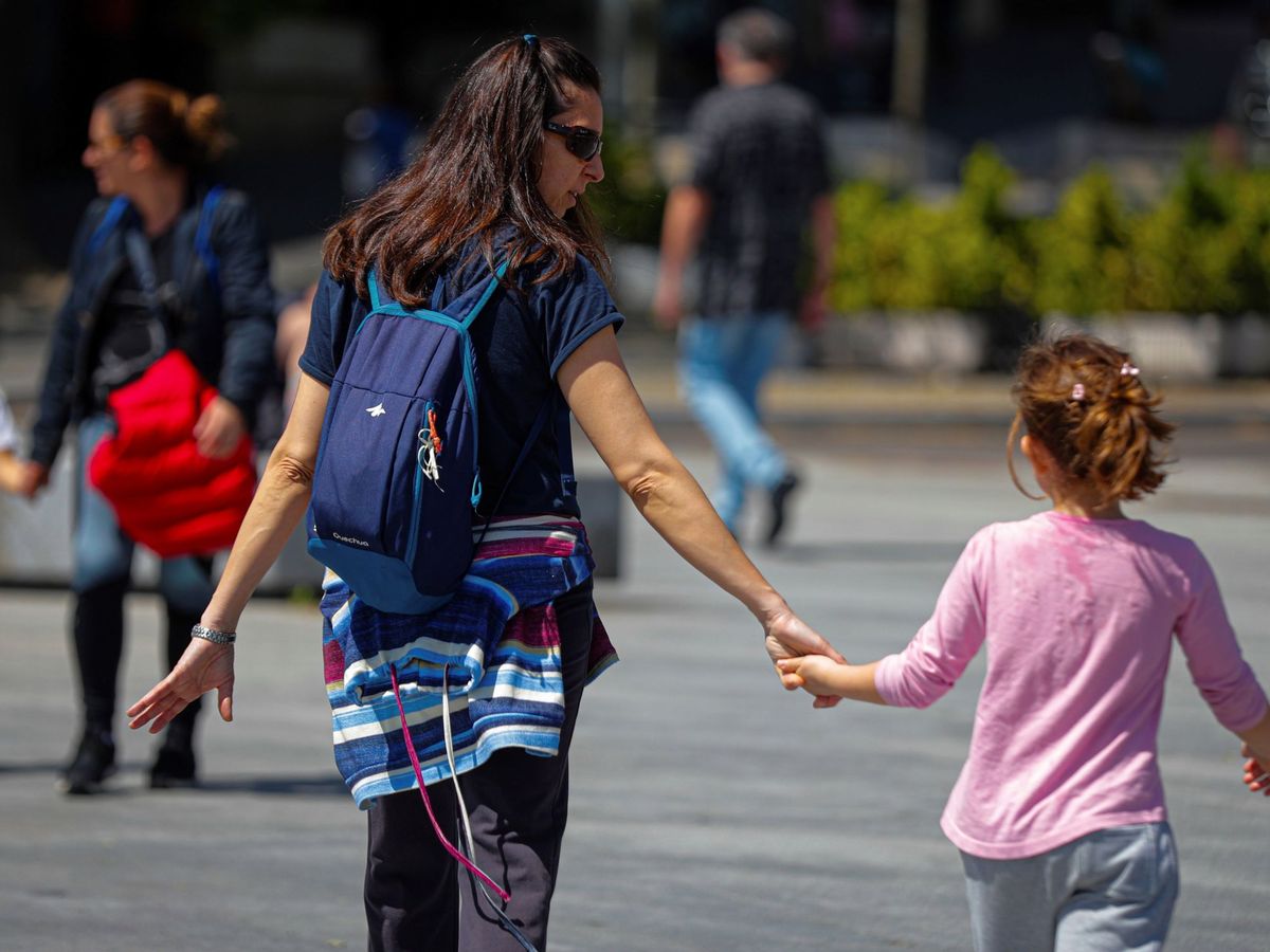 Foto: Una madre pasea con su hija por Madrid. (EFE)