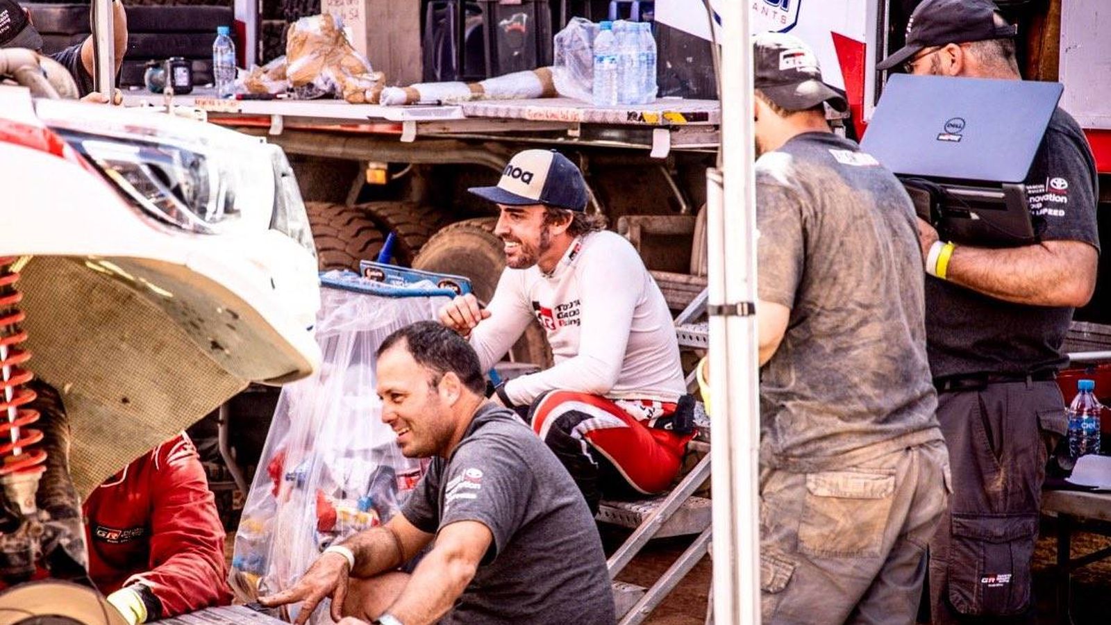 Foto: Fernando Alonso con sus mecánicos, mientras reparaban los desperfectos de la avería que provocó el abandono en la tercera etapa. (Fernando Alonso)