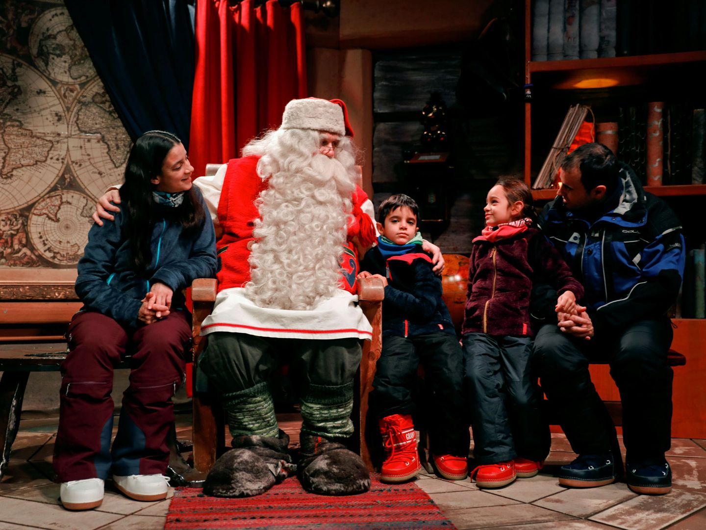Unos visitantes se hacen una foto con Papá Noel en su pueblo de Rovaniemi (Reuters/Pawel Kopczynski)