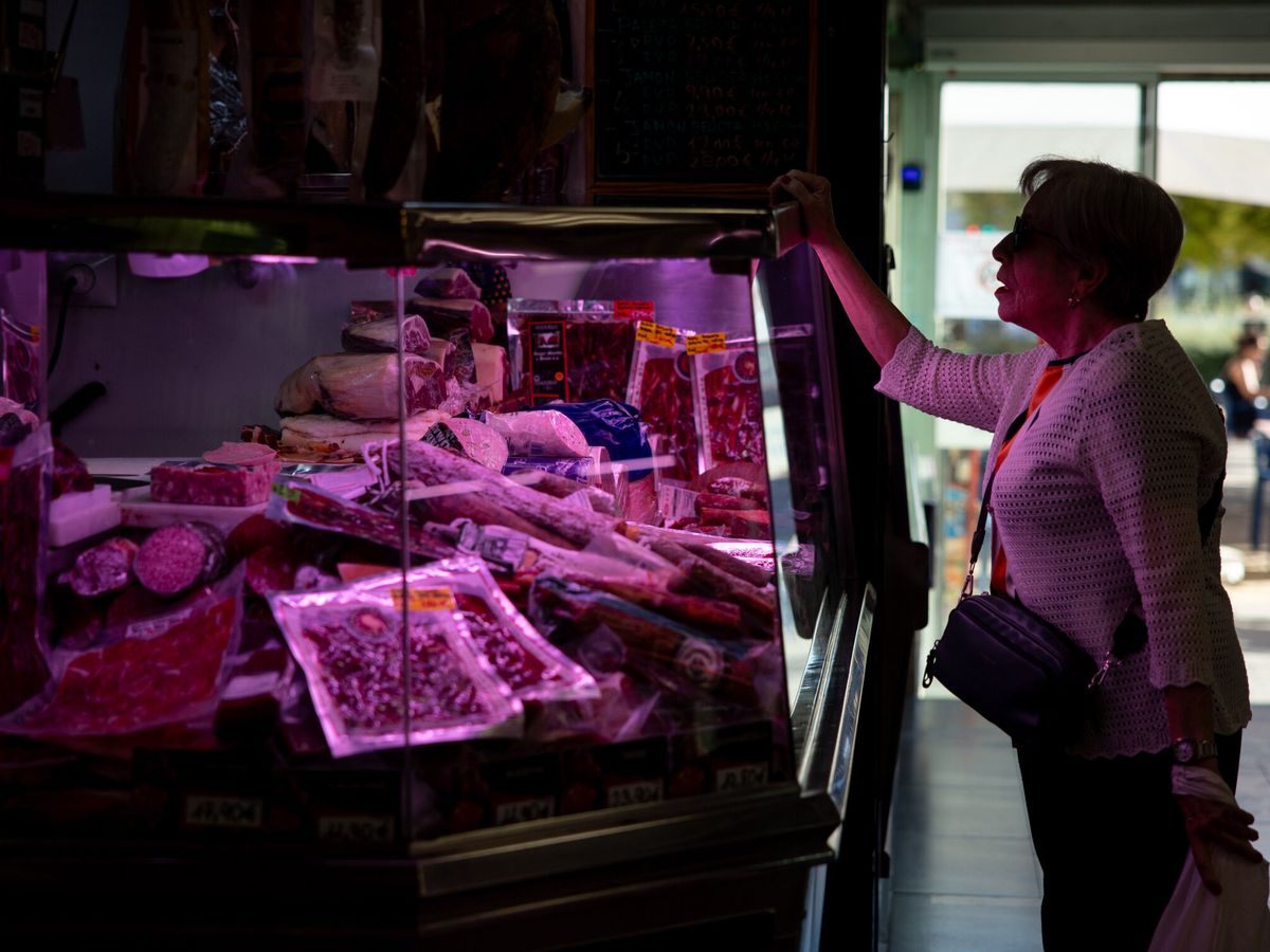 Foto: Una mujer compra en una carnicería en un mercado de Madrid. (EFE/Daniel González)