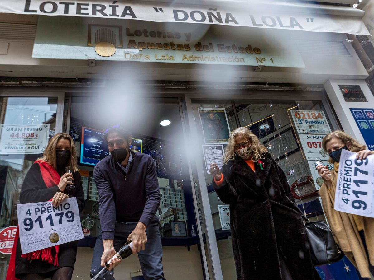Foto: Trabajadores de la administración Doña Lola, en Toledo, celebran el cuarto premio. (EFE/Ángeles Visdómine) 