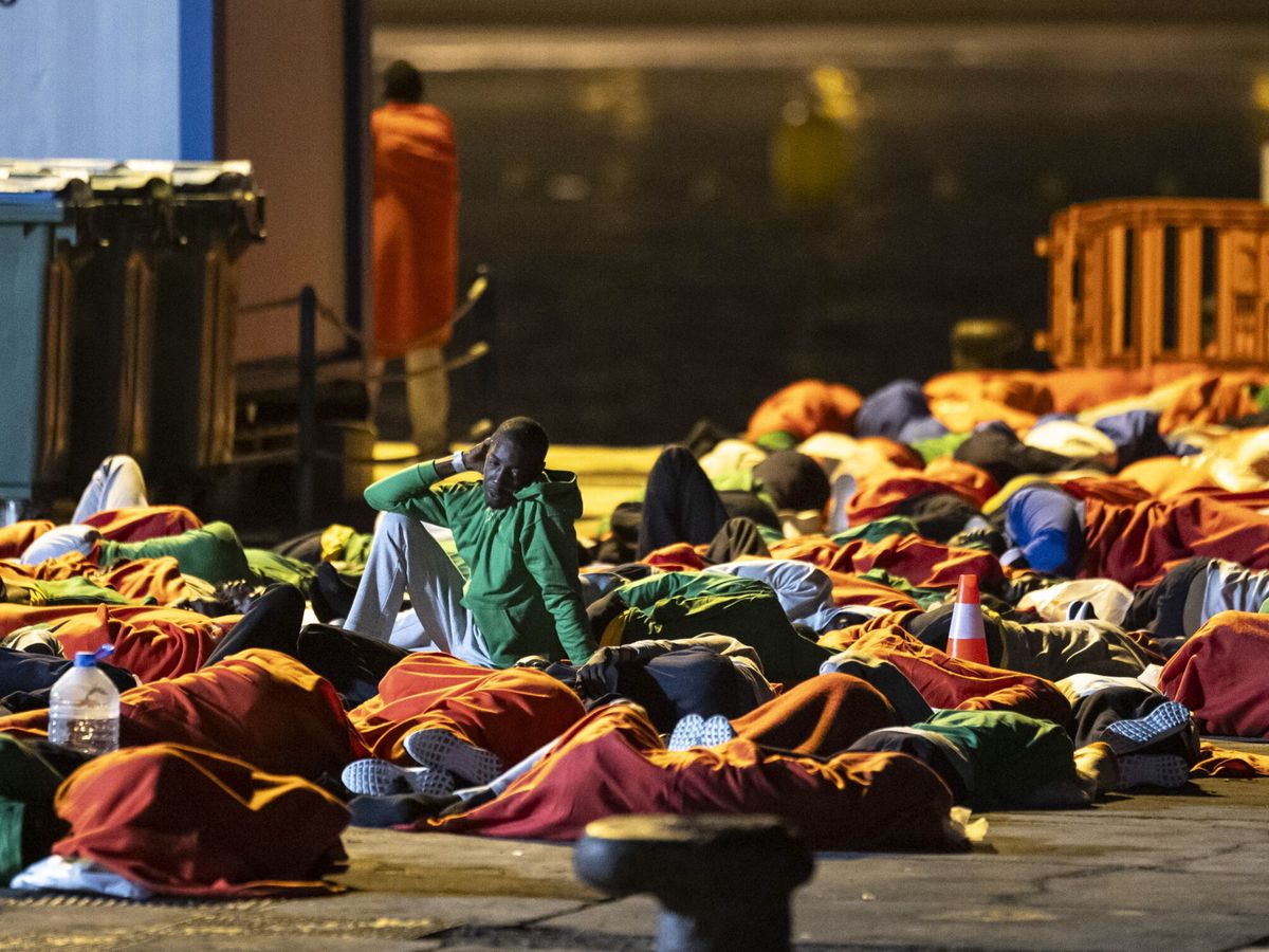 Foto: Unos 200 migrantes que llegaron en la tarde noche del viernes a Tenerife en dos cayucos y durmieron en el muelle de Los Cristianos, ante la falta de espacio en los centros de acogida. (EFE/Miguel Barreto)