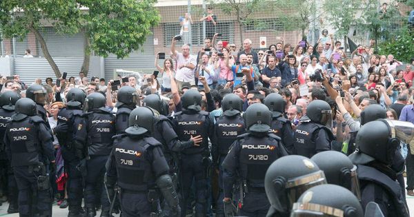 Foto: Agentes de la policía nacional forman un cordón policial en el IES Tarragona el 1 de octubre de 2017. (EFE)