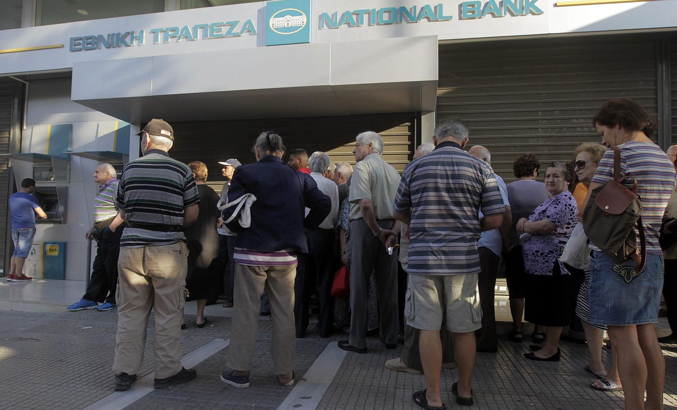 Griegos esperan para poder sacar dinero en un cajero de Atenas. (Efe)