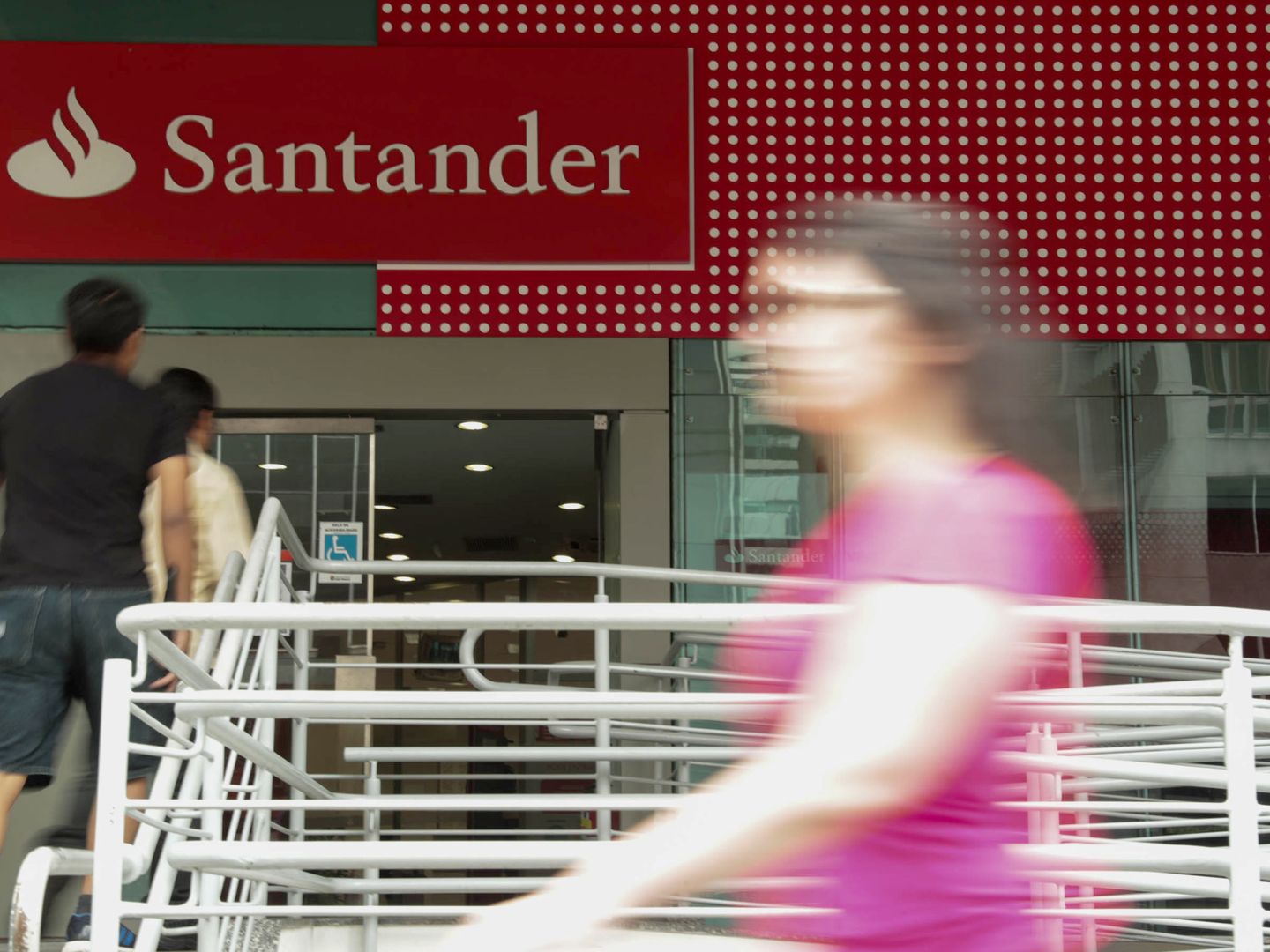 Varias personas caminan frente a una sucursal del banco Santander. (EFE)