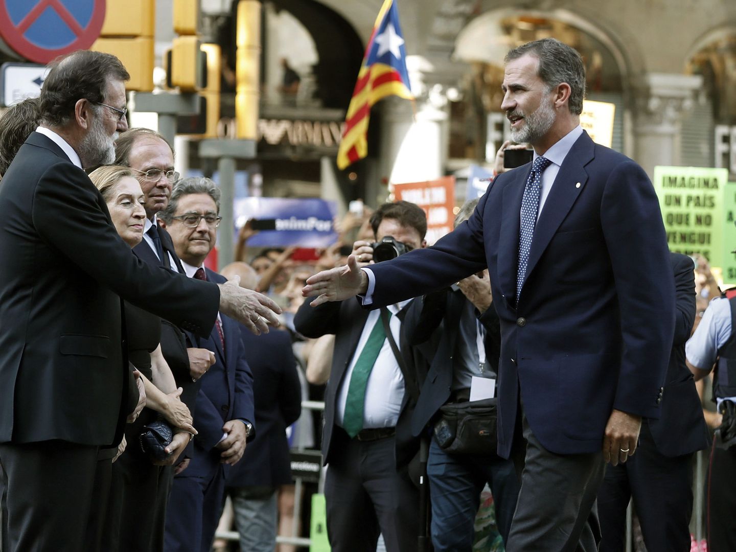 El rey Felipe VI saluda a Mariano Rajoy durante la manifestación contra los atentados yihadistas en Cataluña, con independentistas de fondo. (EFE/Andreu Dalmau)