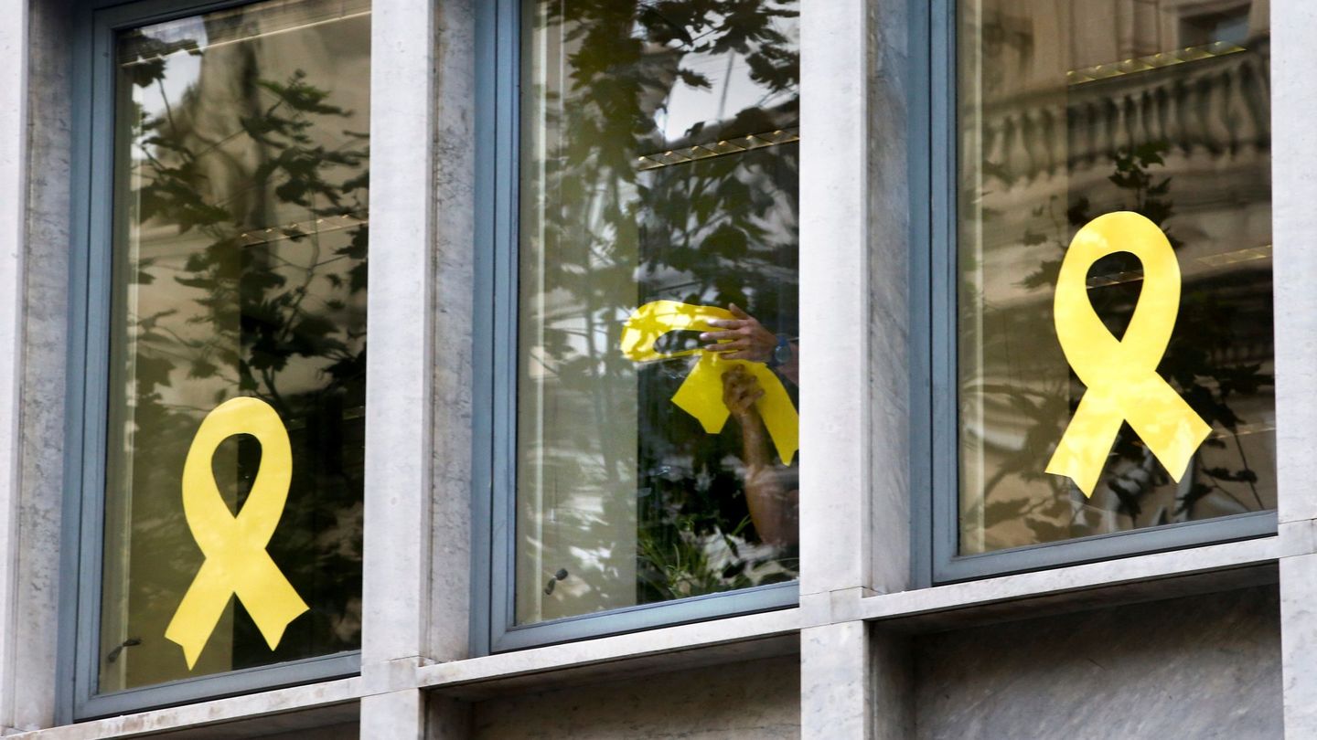 Trabajadores del Departamento de Agricultura de la Generalitat retiran lazos de las ventanas del edificio de la consejería. (EFE)