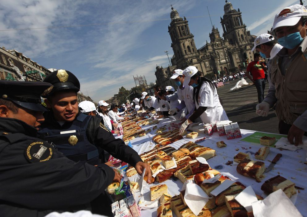 Foto: Dos policías comen el tradicional Roscón de Reyes en una calle de Ciudad de México. (Reuters)