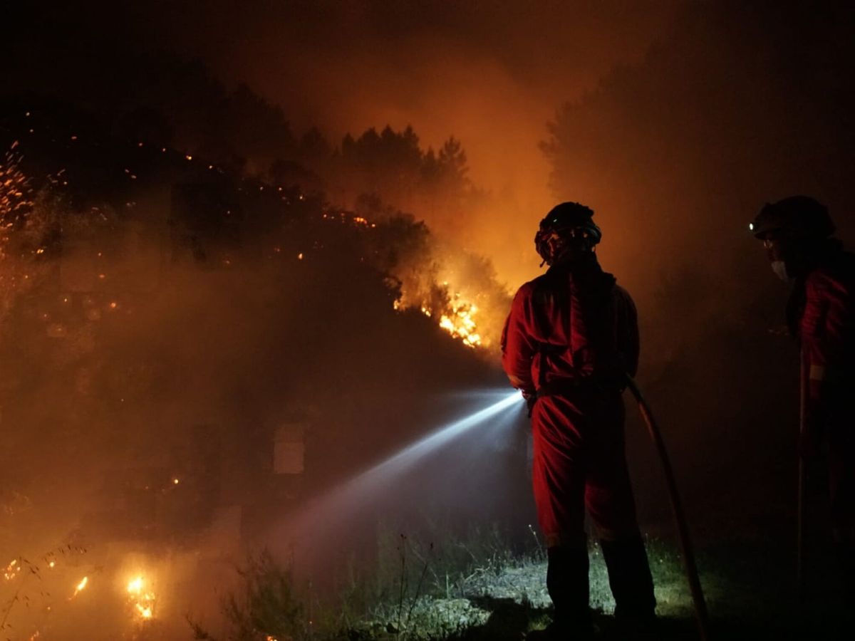 Foto: Un bombero de Infocaex en el incendio por la noche. (EFE/Ministerio de Defensa) 