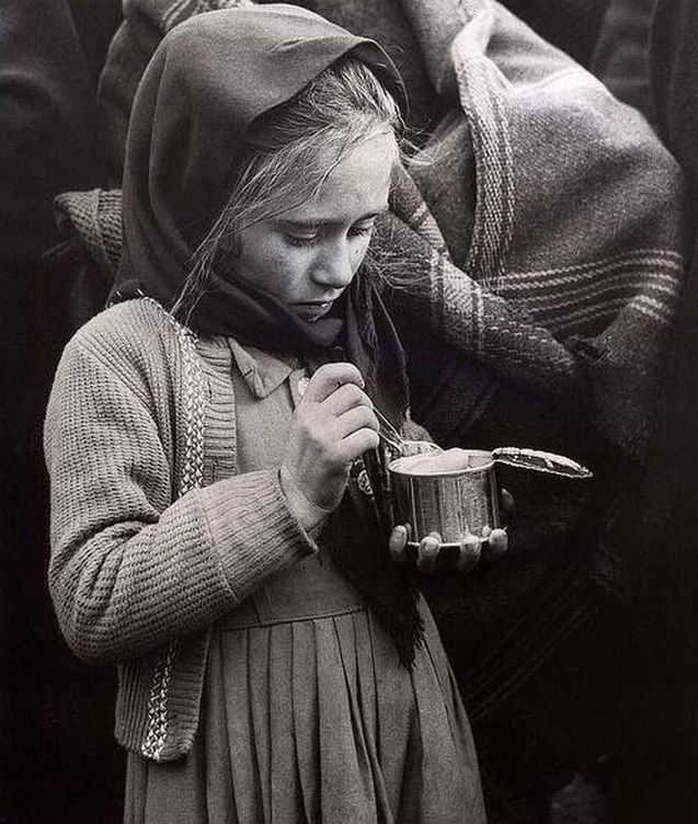 Una niña come de una lata de conservas el día siguiente de la catástrofe de Ribadelago. (EFE)