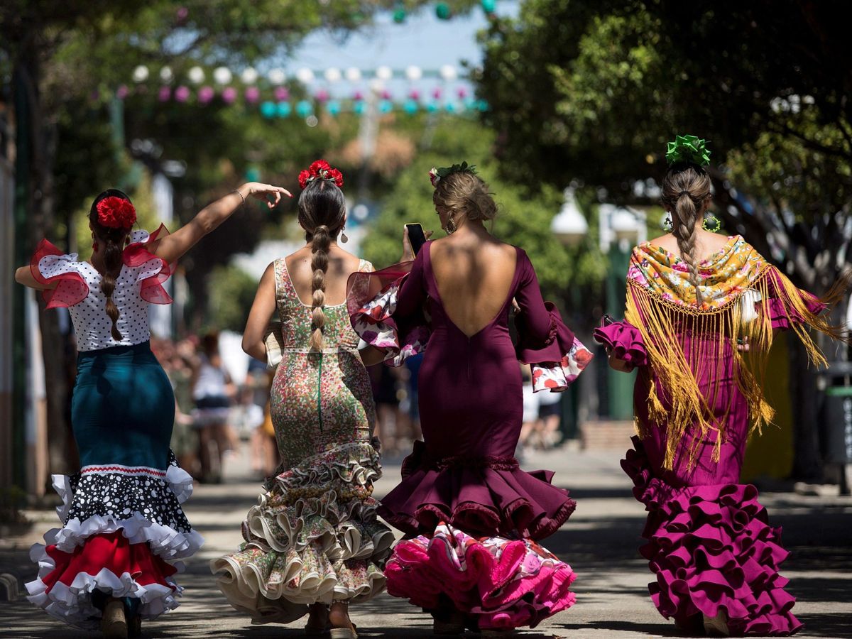 Foto: Varias personas vestidas con el traje de flamenca en el Real de la Feria de Málaga 2019. (EFE)