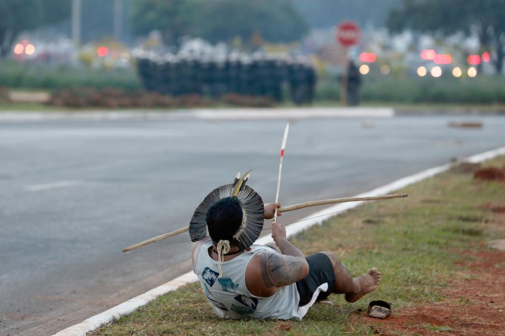 Un indígena apunta contra la Policía en una protesta en Brasilia (Efe). 