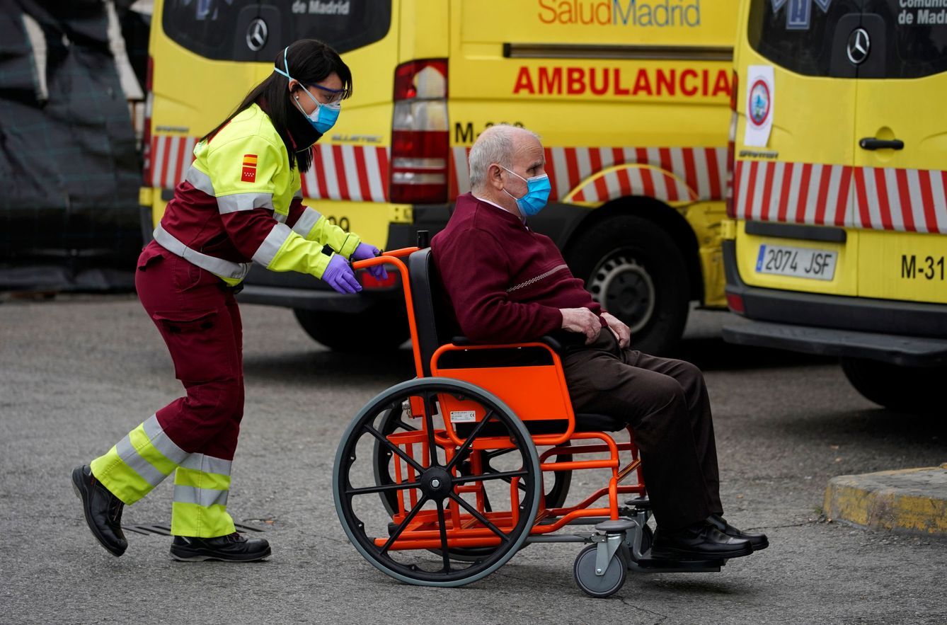 Una operaria de ambulancias, junto a un enfermo, en el Hospital 12 de Octubre de Madrid. (Reuters)