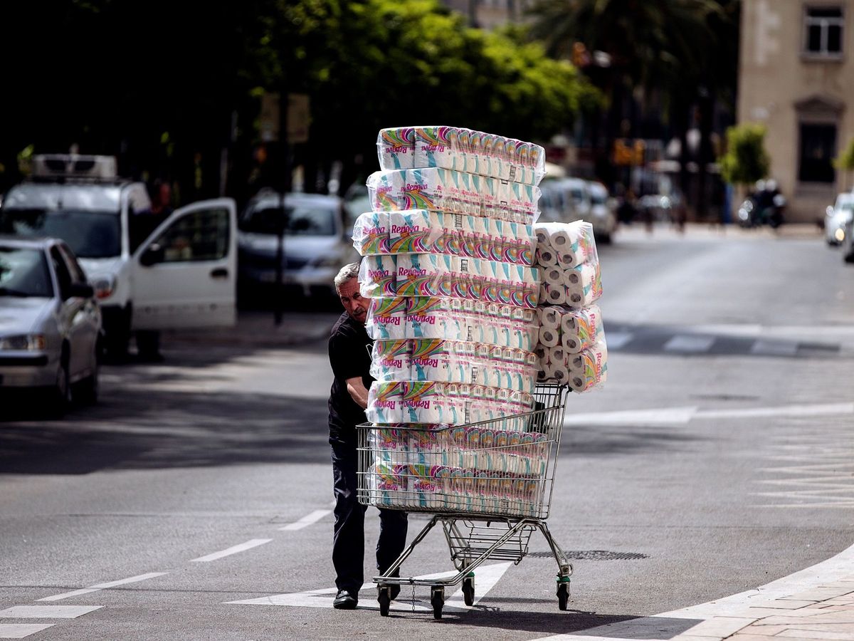 Foto: Un trabajador transporta numerosos rollos de papel higiénico (EFE)