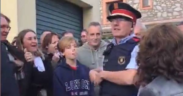 Foto:  Uno de los mossos informa a los votantes de la orden que tienen de entrar. (EC)
