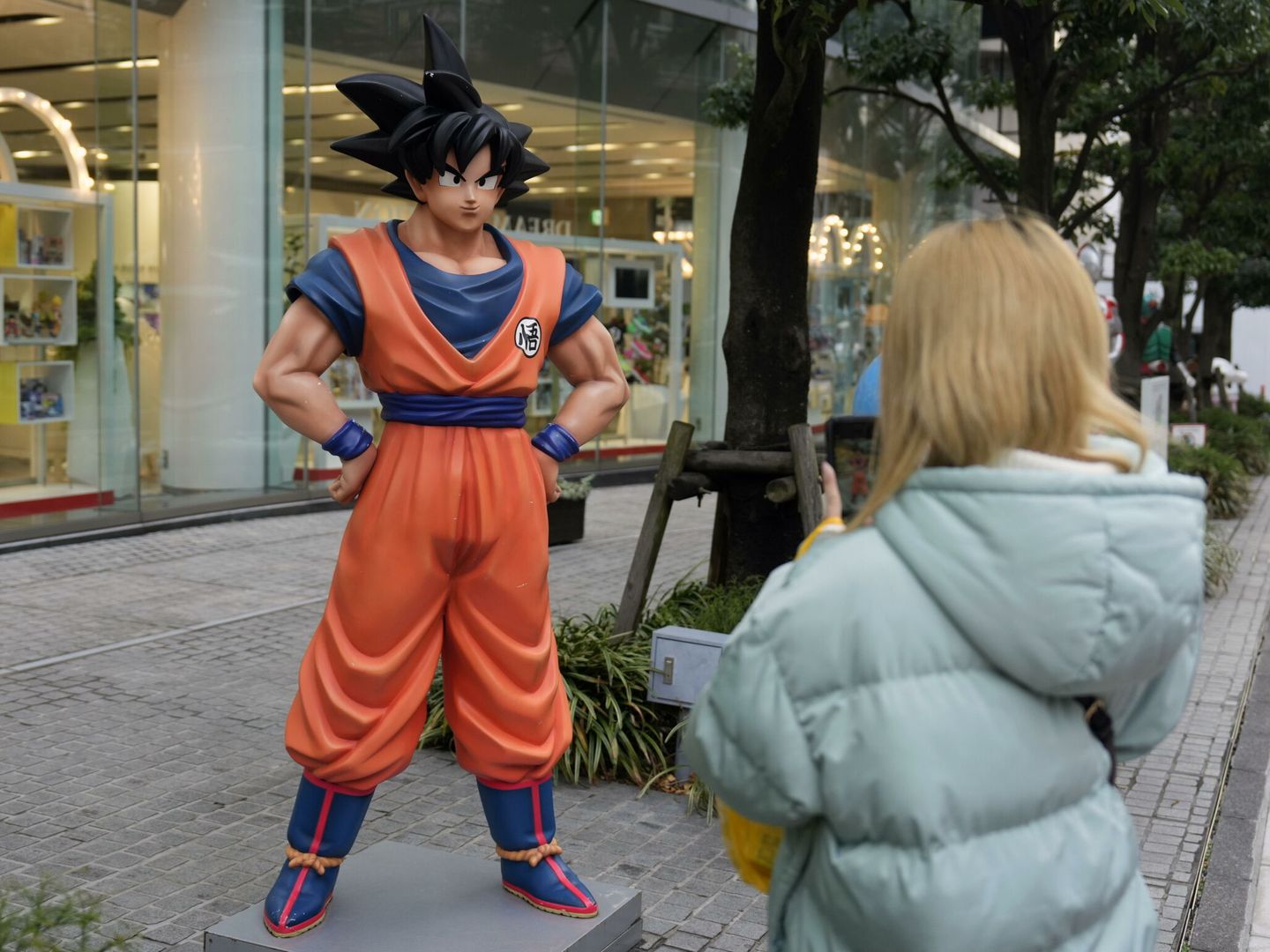 Un turista toma fotos de una estatua de Son Goku. (EFE/EPA/Franck Robichon)