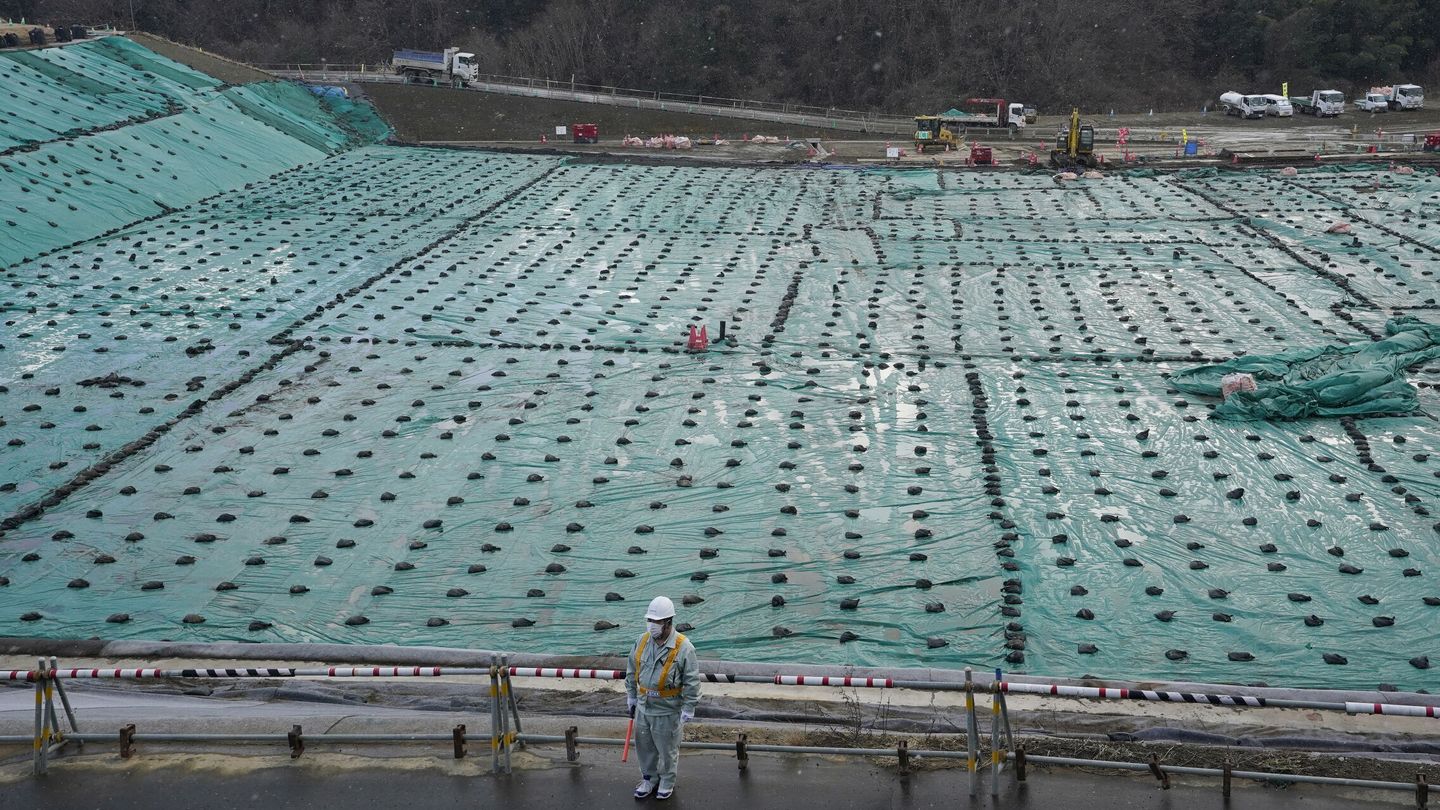 Un hombre controla el tráfico en una instalación de almacenamiento provisional de Fukushima. (EFE)