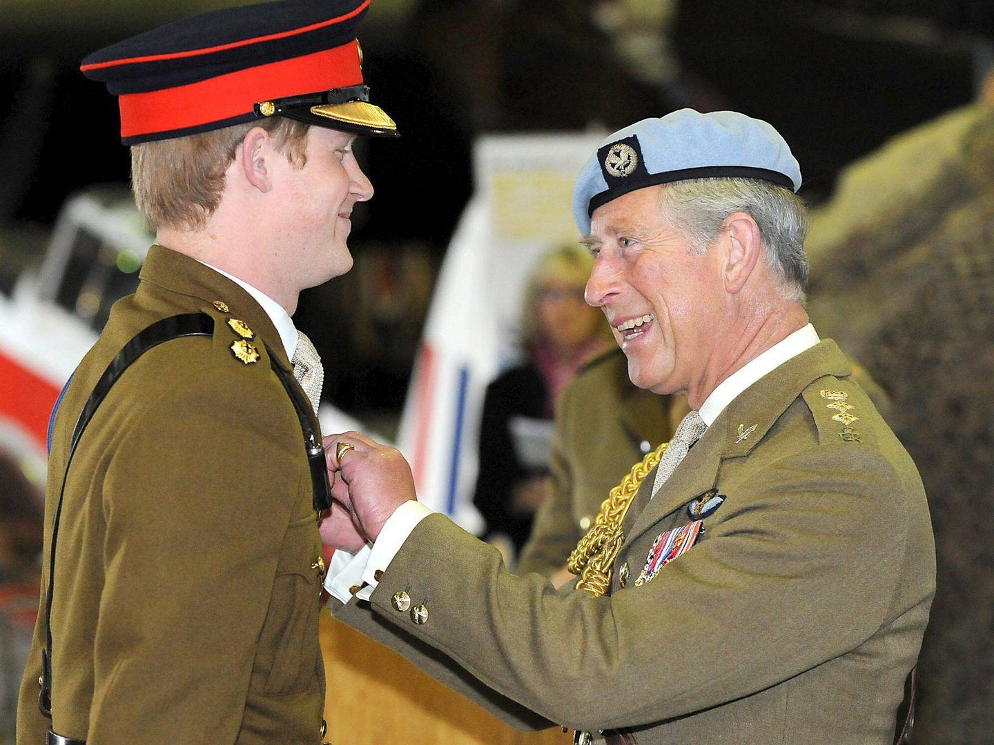 El príncipe Harry recibiendo de manos de su padre las 'alas' que le acreditan como piloto de helicóptero. (EFE)