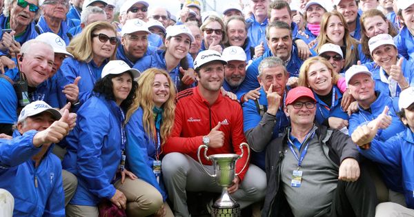 Foto: Jon Rahm posa con el trofeo del Open de España y el personal del torneo. (EFE)