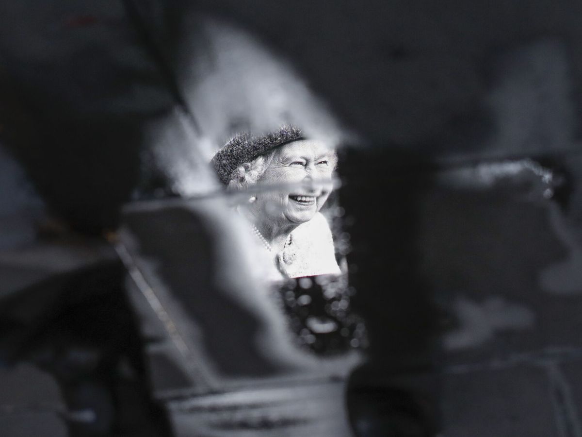 Foto: Vista de la imagen de Isabel II reflejada en un charco en Piccadilly Circus, en Londres. (EFE/Olivier Hoslet)