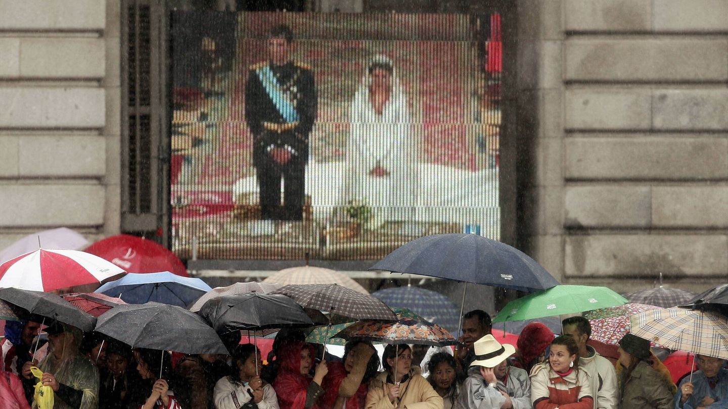 El pueblo de Madrid, con paraguas, viendo la boda en pantalla. (Getty)