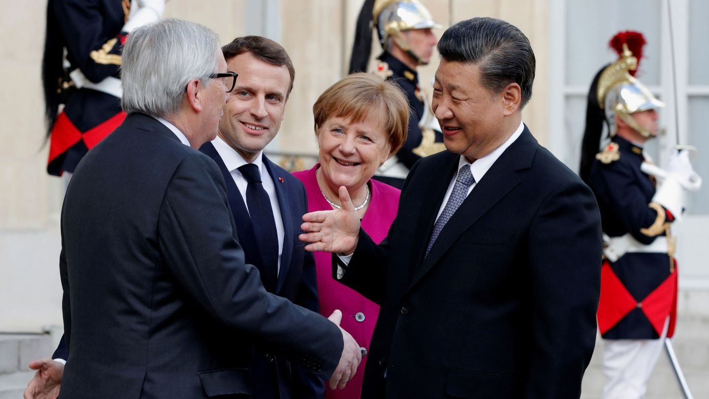 El presidente de la Comisión Europea saluda al presidente chino ante las miradas de Macron y Merkel. (Reuters)