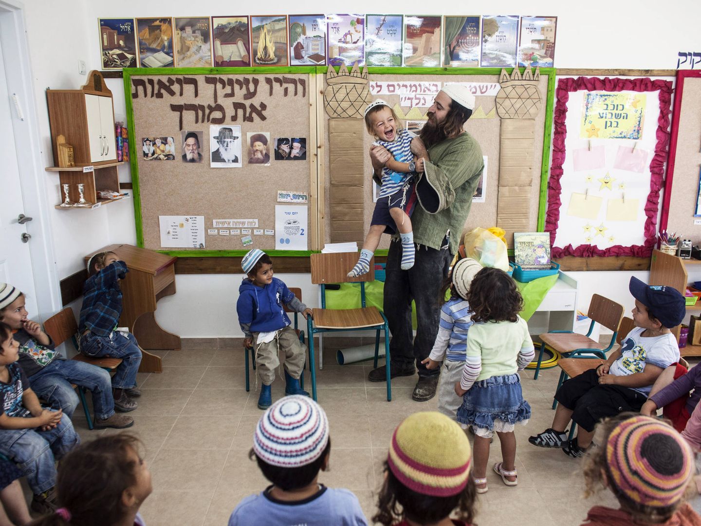 Natanel, un profesor, juega con un niño en la colonia de Havat Gilad, al sur de Nablús, en Cisjordania (Reuters).