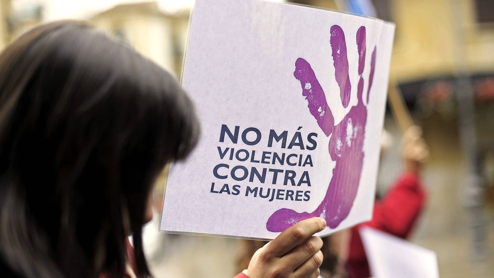 Foto: Una mujer camina junto a un cartel contra la violencia machista durante una manifestación. (EFE)