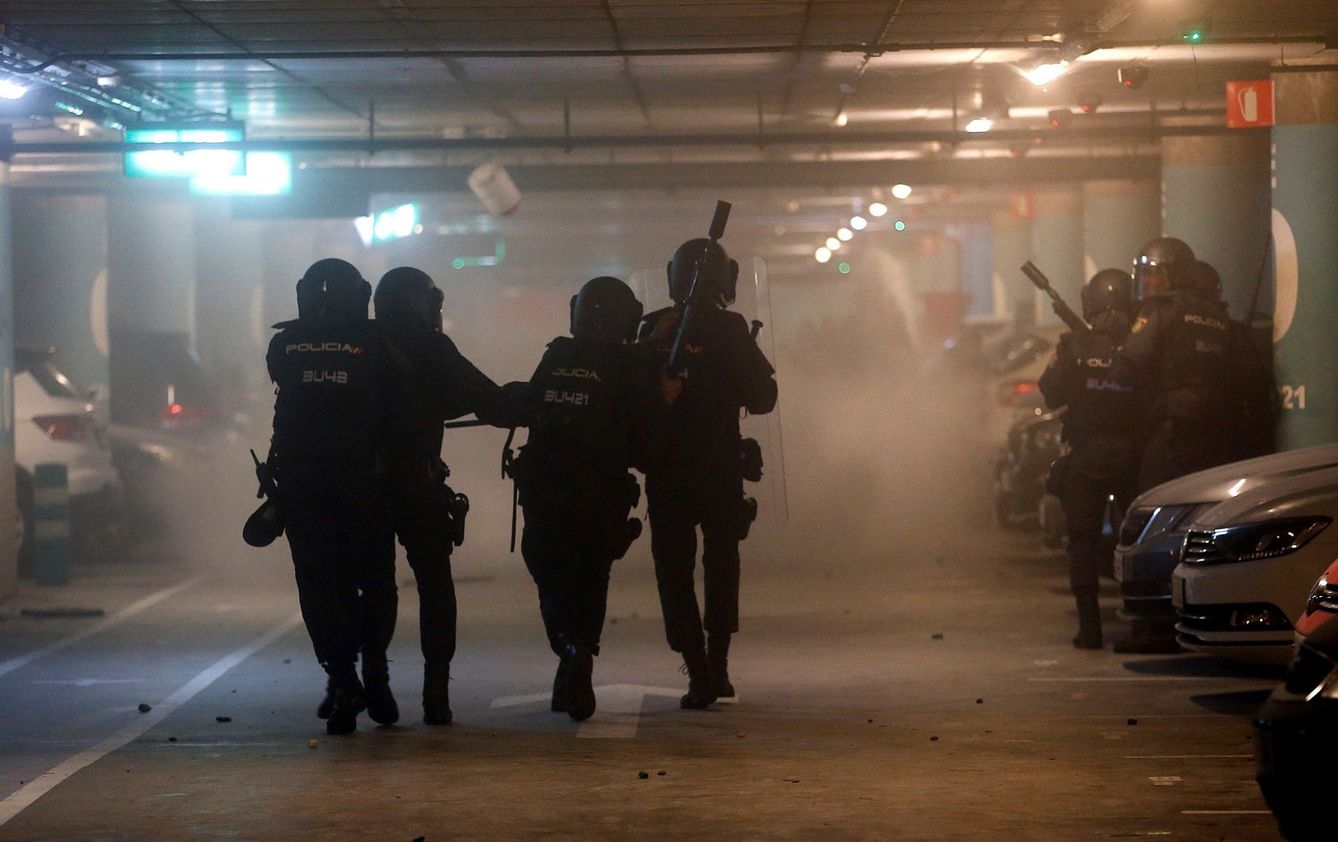 Miembros de la Policía Nacional cargan contra manifestantes este lunes en el parking del Aeropuerto de El Prat. (EFE)