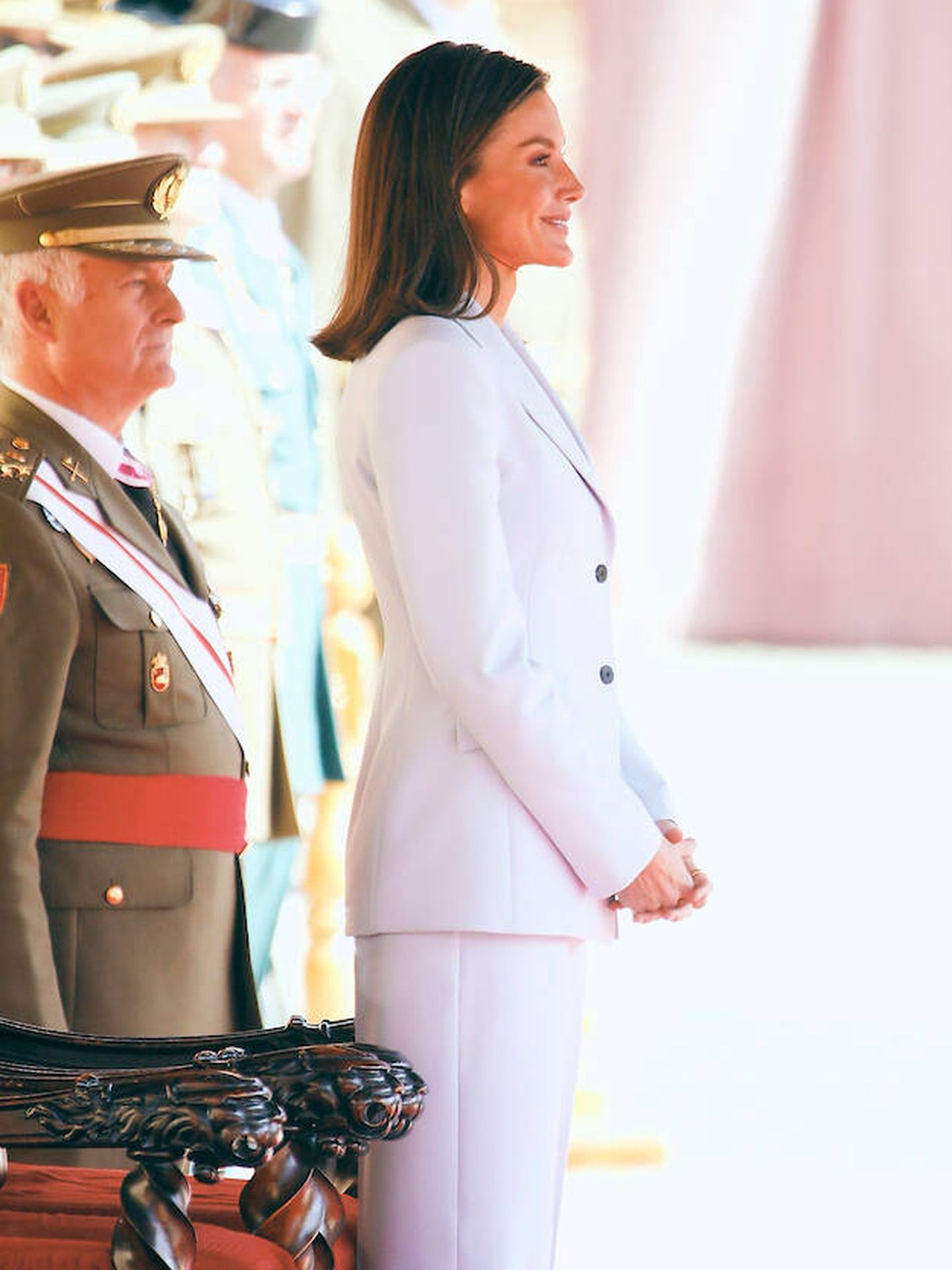 La reina Letizia, sonriendo mientras Felipe VI besa la bandera. (LP)