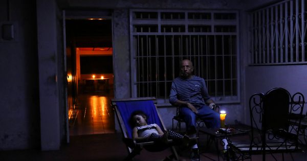 Foto: Una familia descansa en la puerta de su casa durante el apagón en la ciudad venezolana de Puerto Ordaz, el 9 de marzo de 2019. (Reuters)