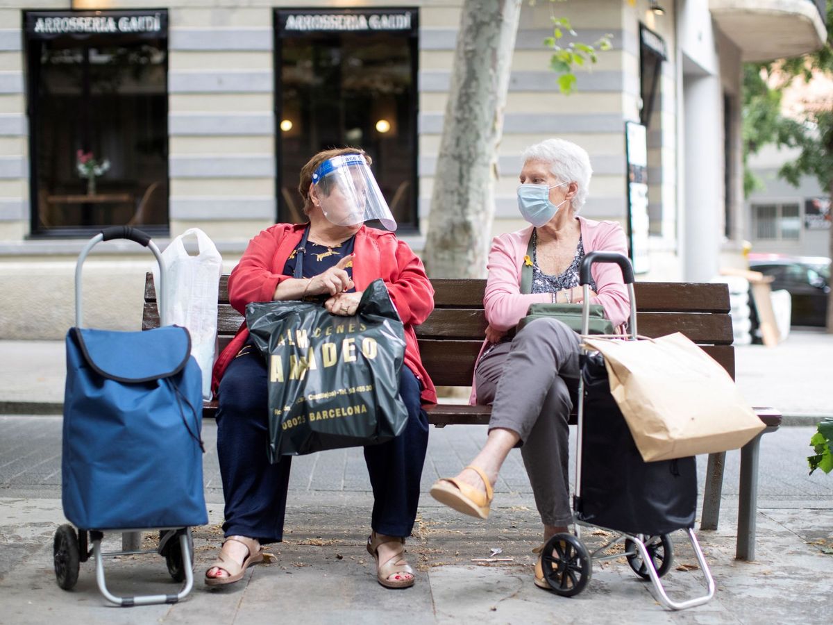 Foto: Dos señoras charlan sentadas en un banco del barcelonés barrio de la Sagrada Familia. (EFE)